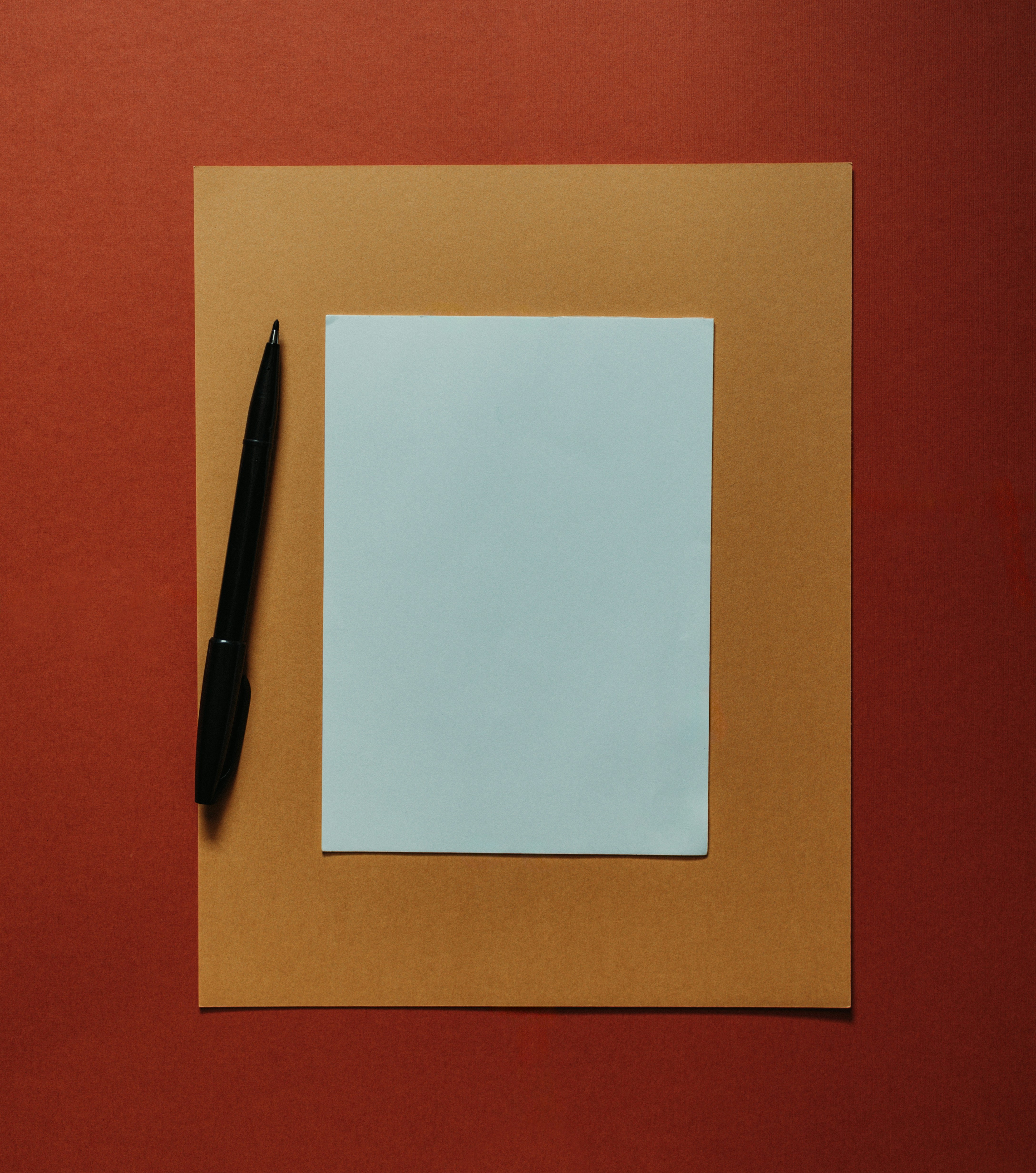 A blank sheet of paper and pen on an orange background