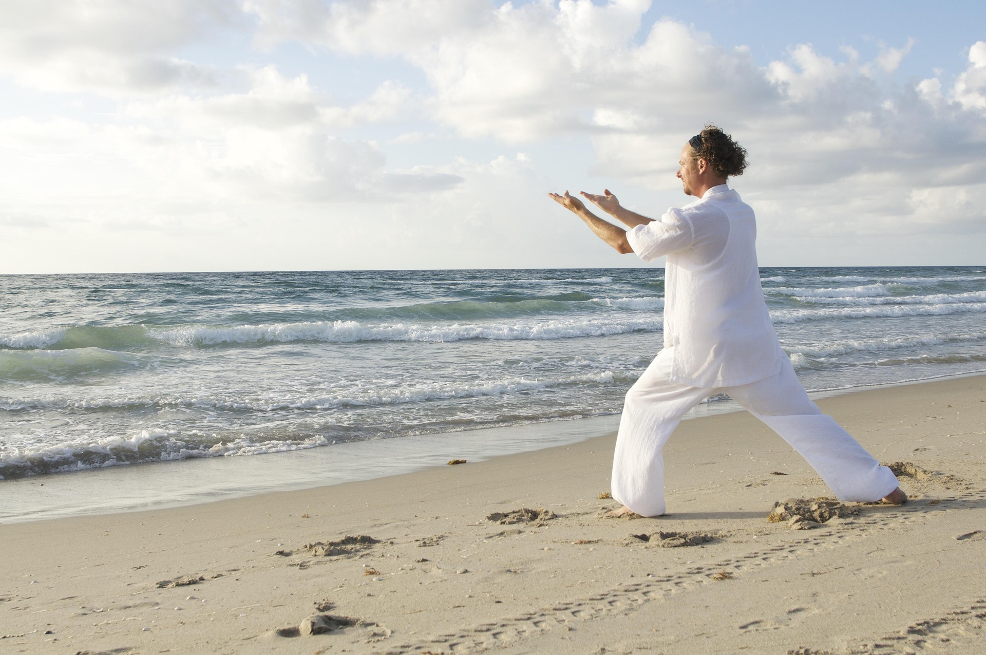 View of a person doing tai chi on the beach