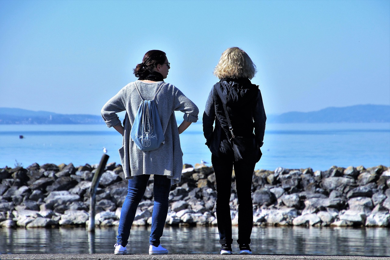 Two women talking by the ocean