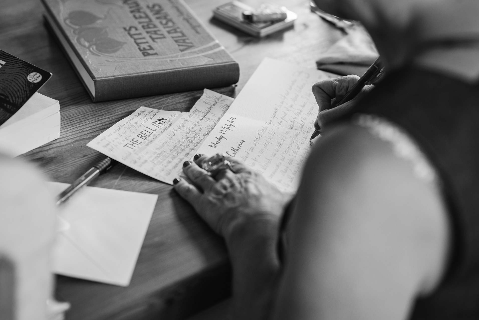 Person sitting at a table making a list